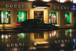 Loja Gucci à noite com vitrines iluminadas, uma das marcas de roupas mais famosas do segmento premium.