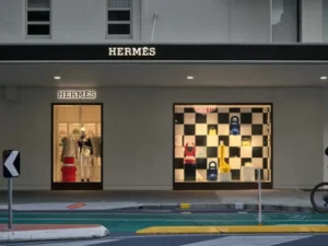 Fachada da loja Hermès com vitrines iluminadas, ícone do luxo e da moda internacional.