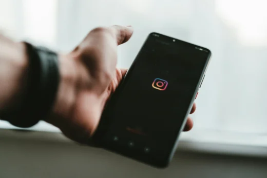 Pessoa segurando smartphone com logo do Instagram na tela, ilustrando cotna suspensa no instagram e acesso bloqueado