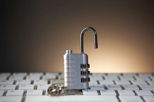 Cadeado aberto sobre teclado simboliza vulnerabilidade digital e risco de vazamento de dados em sistemas online.